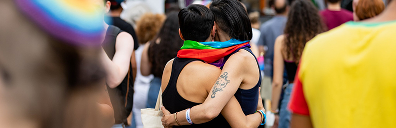 A couple embracing at in a crowd at Montclair Pride, in Montclair, New Jersey
