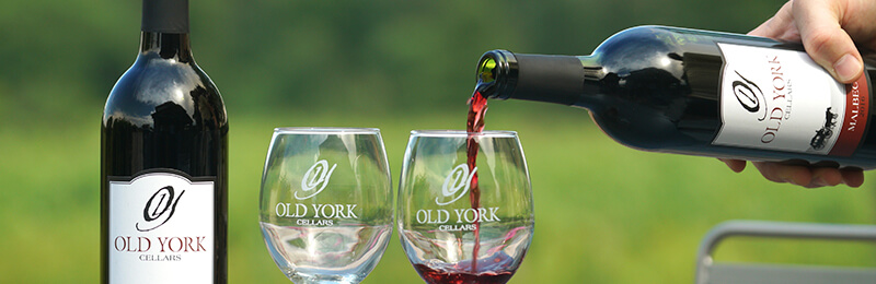 Wine being poured into glasses labeled Old York Cellars