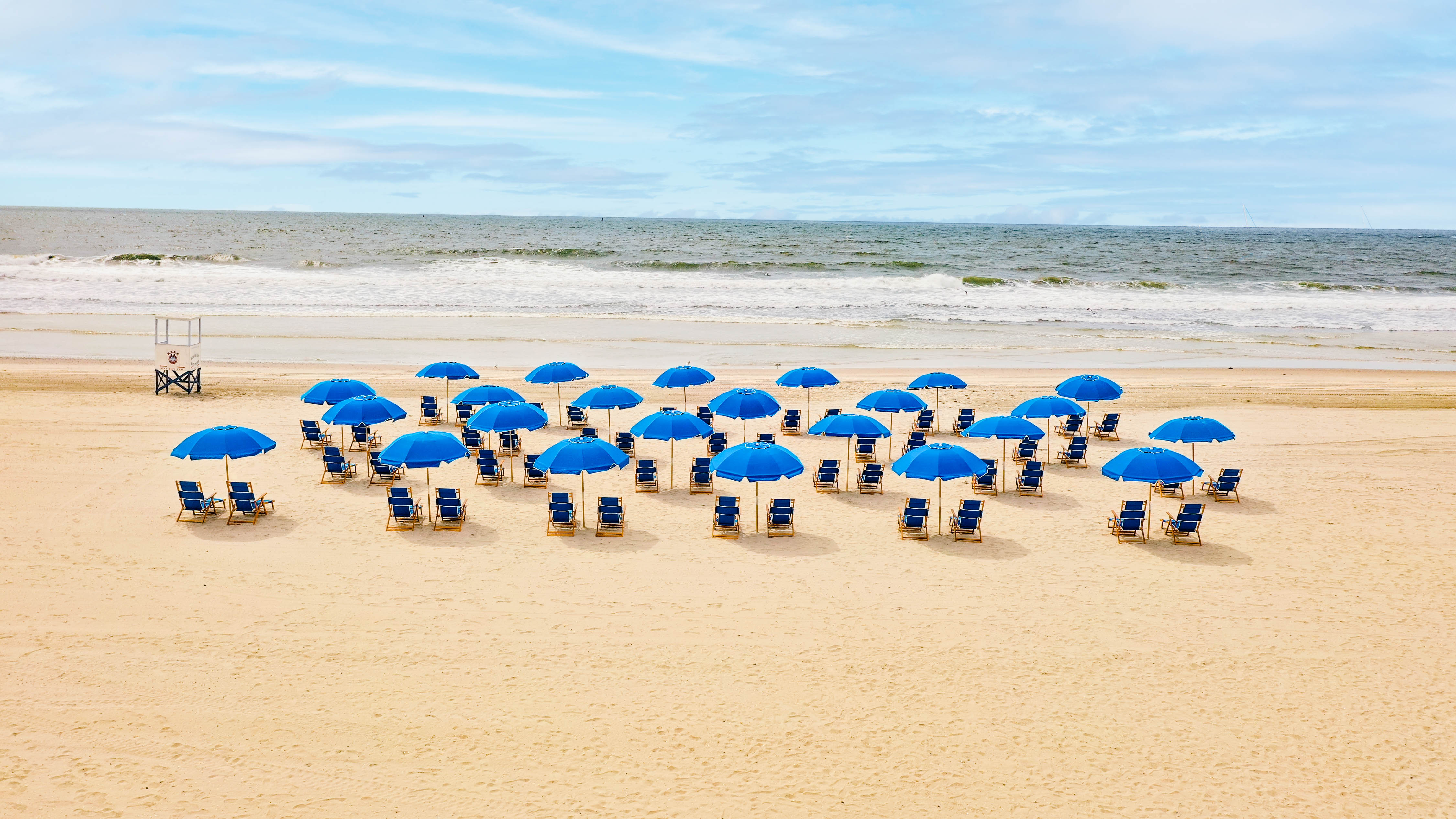 chairs lined up in the sand on the beach