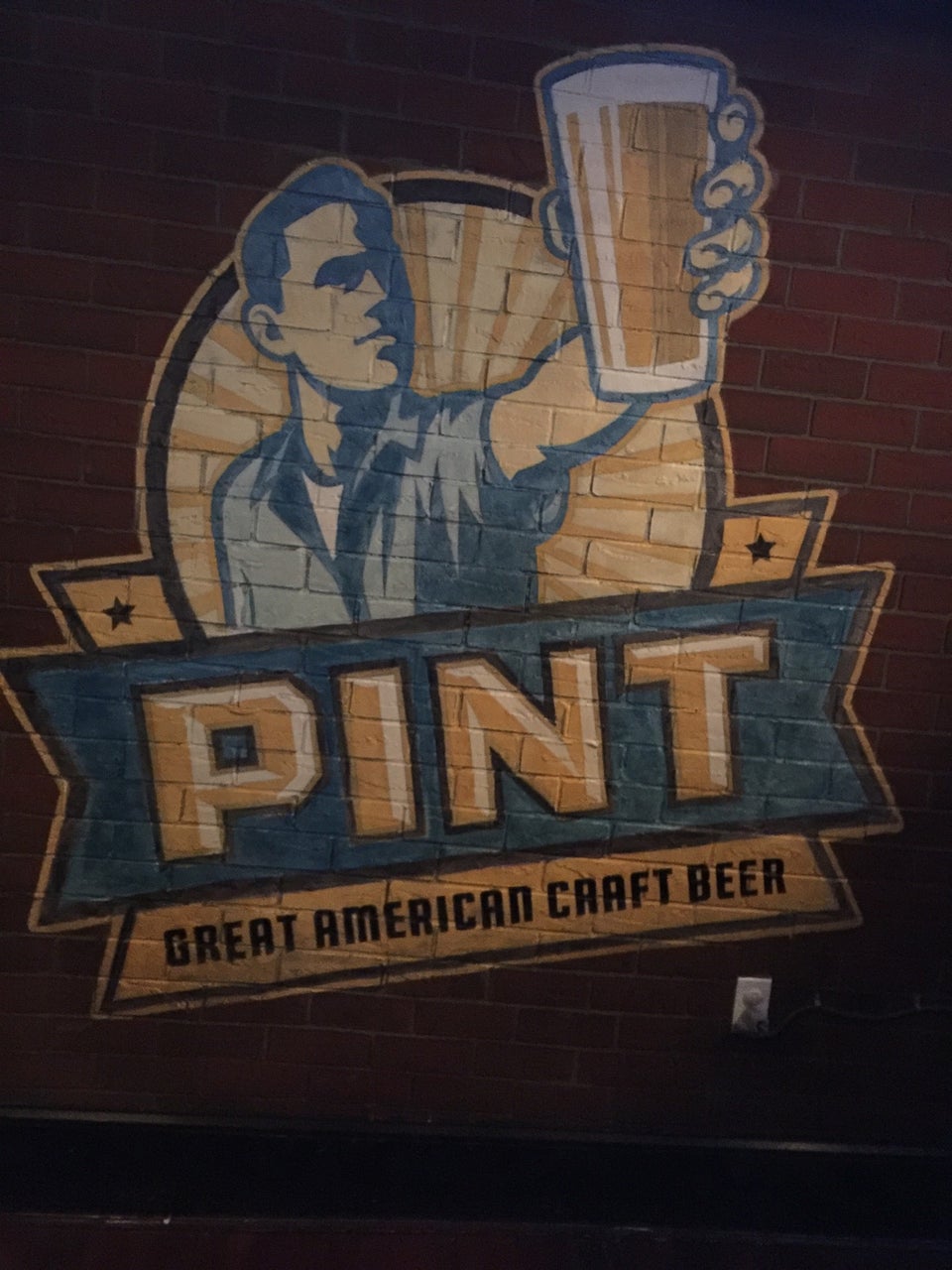 the pint logo painted on brick wall