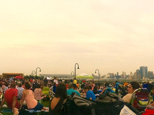 summer sky with patrons enjoying a concert overlooking Manhattan skyline