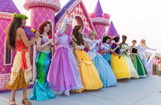 Princesses lined up on stage in colorful gowns