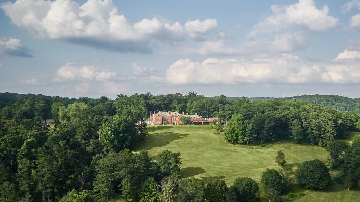 brick mansion on the hill surrounded by lush forest